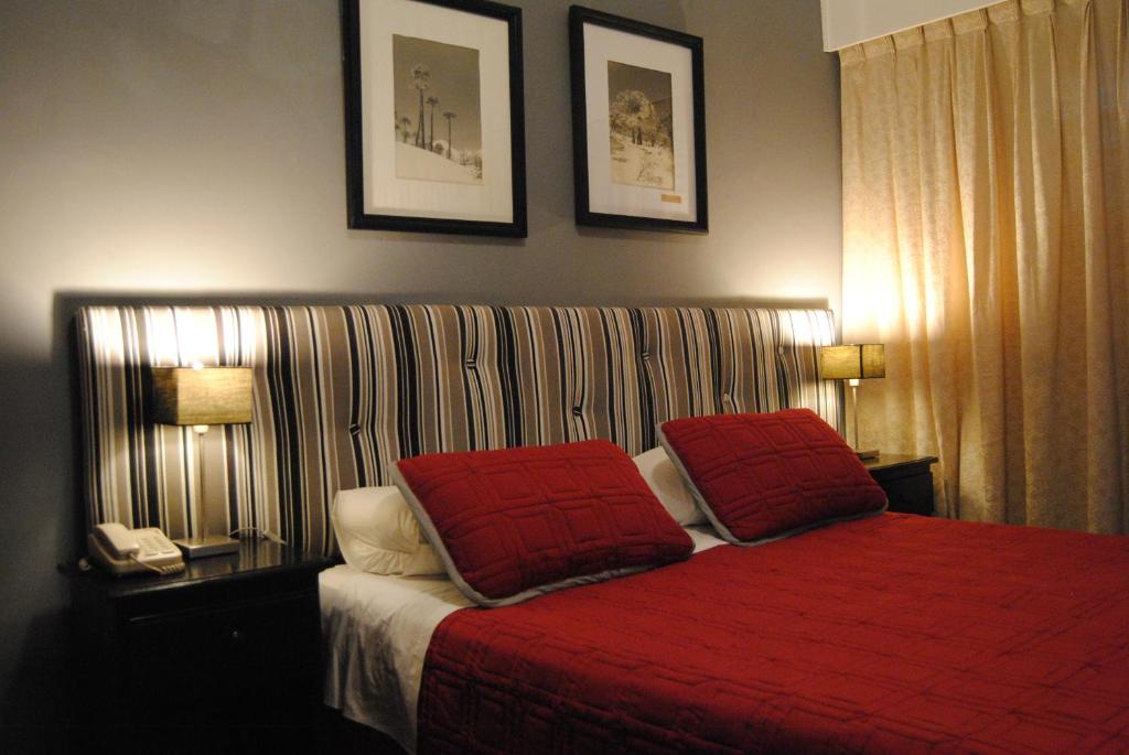 埃斯特角城伊比利亚酒店的一间卧室配有红色的床和两个红色枕头
