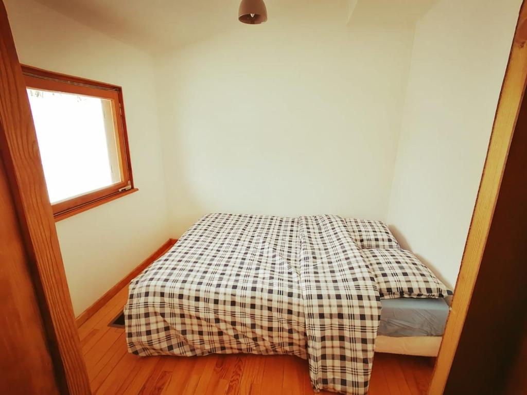 科尔鲁瓦拉罗克La clé des champs的一间卧室配有一张带 ⁇ 子毯子的床