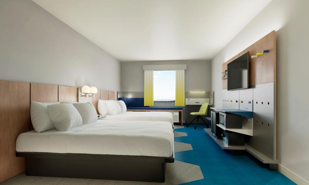 梅干提克湖Microtel Inn Suites by Wyndham Lac-Megantic的酒店客房设有一张大床和一张书桌。