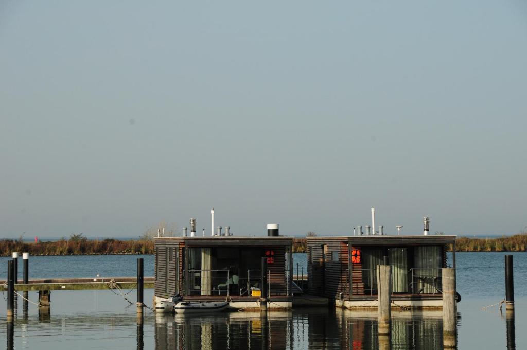 莱利斯塔德Mermaid- Hausboote的码头旁的水面上的小房子