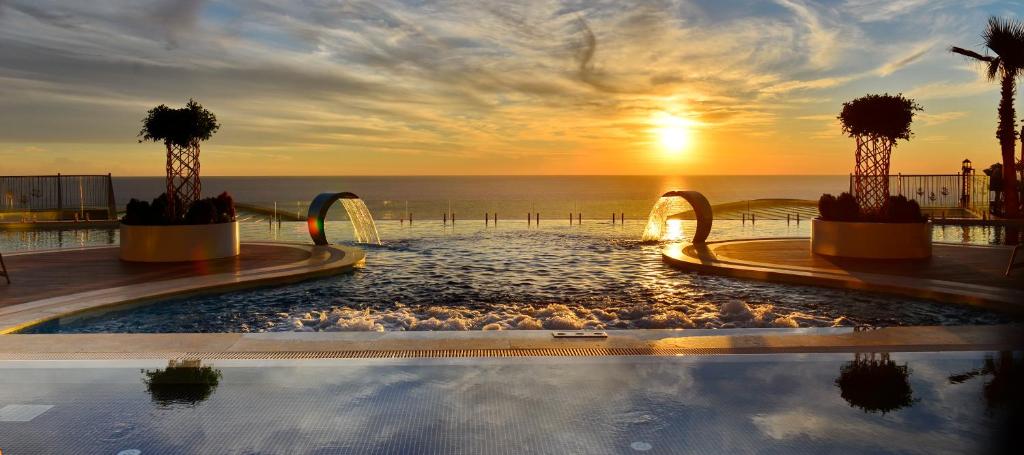 阿拉尼亚Elite Luxury Suite & Spa的一座享有日落美景的游泳池