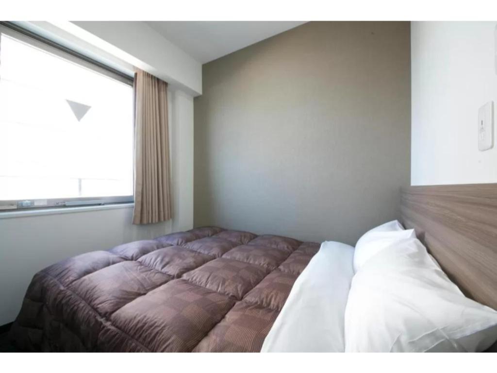 大阪R&B Hotel Shin Osaka Kitaguchi - Vacation STAY 15208v的一张位于带大窗户的房间内的床铺