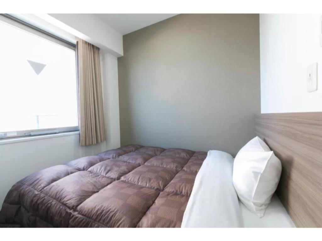 大阪R&B Hotel Shin Osaka Kitaguchi - Vacation STAY 15196v的一间卧室设有一张大床和大窗户