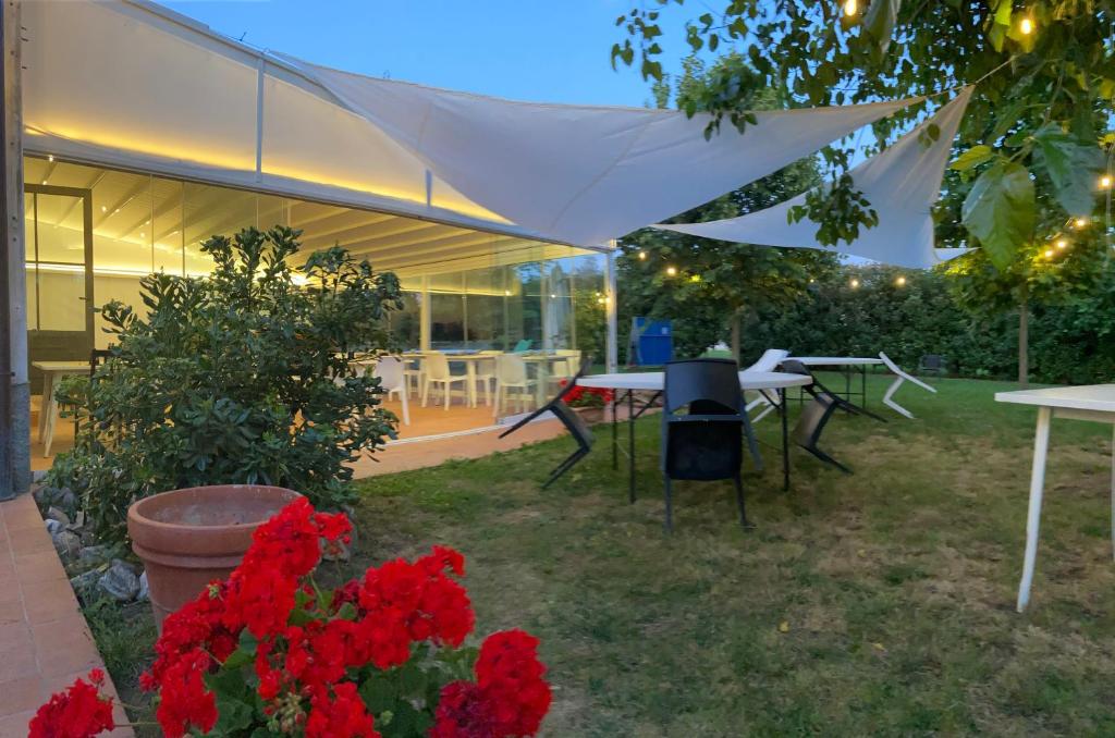萨尔扎纳训马场酒店的庭院里设有桌子和红色鲜花的庭院