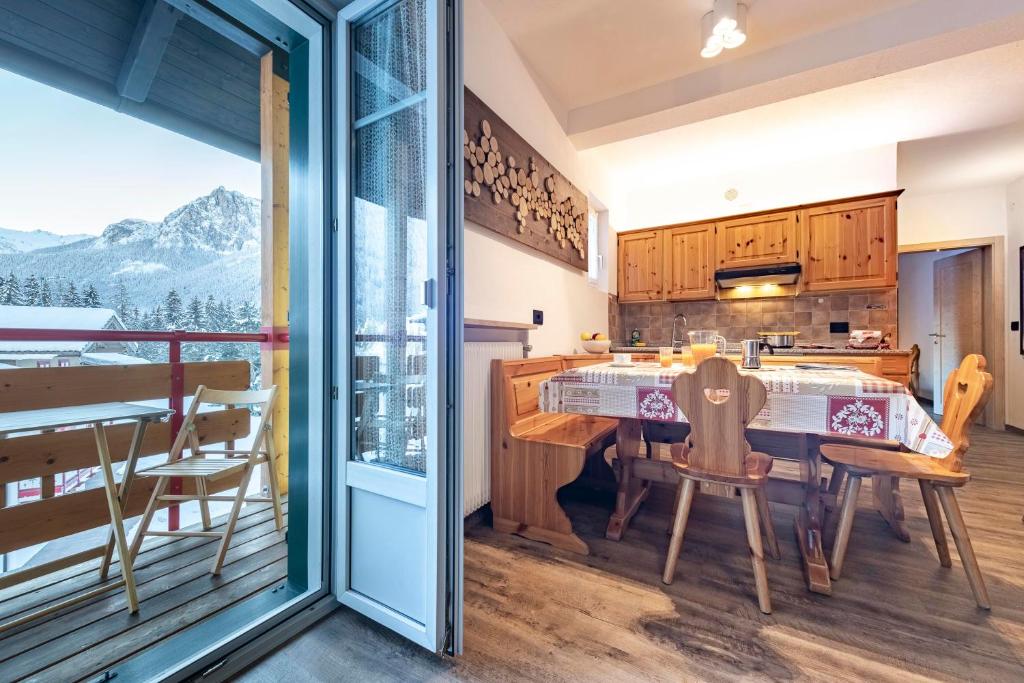 博萨迪法萨Appartamenti Residence La Roggia的一个带桌椅的厨房和一个阳台