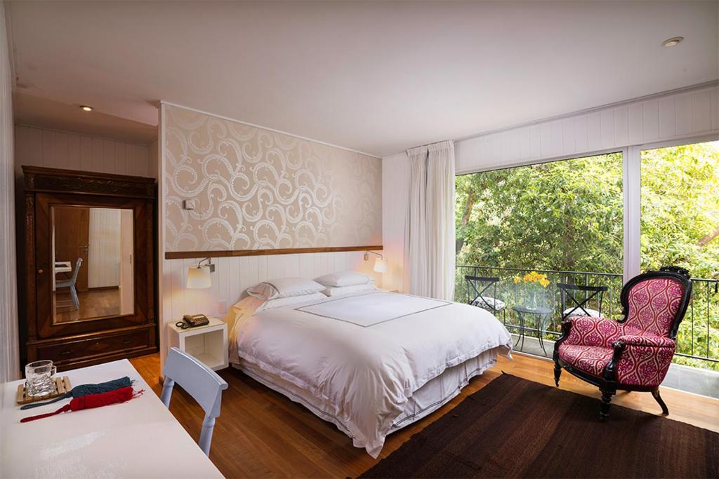萨帕利亚尔卡萨萨帕拉尔酒店的卧室配有床、椅子和窗户。