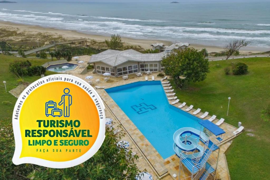 拉古纳Samba Laguna Tourist Hotel的海滩旁游泳池前的标志