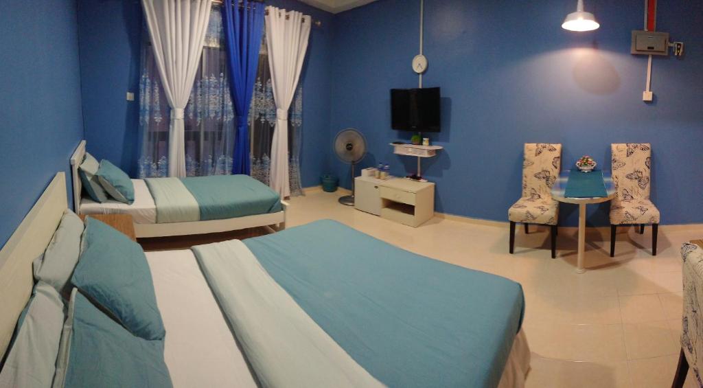 哥打巴鲁AlRayani Guest Room, Homestay Kota bharu的蓝色的客房配有两张床和电视。
