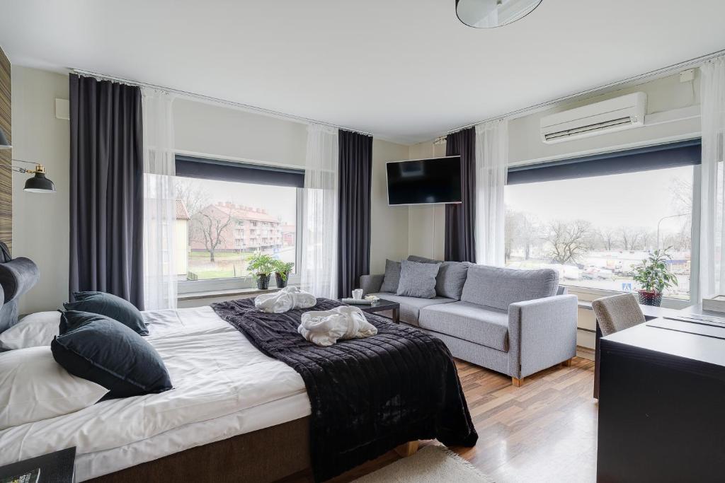 法格斯塔法格斯塔瓦德西塞特C狄更斯酒店的一间卧室配有一张床、一张沙发和窗户。