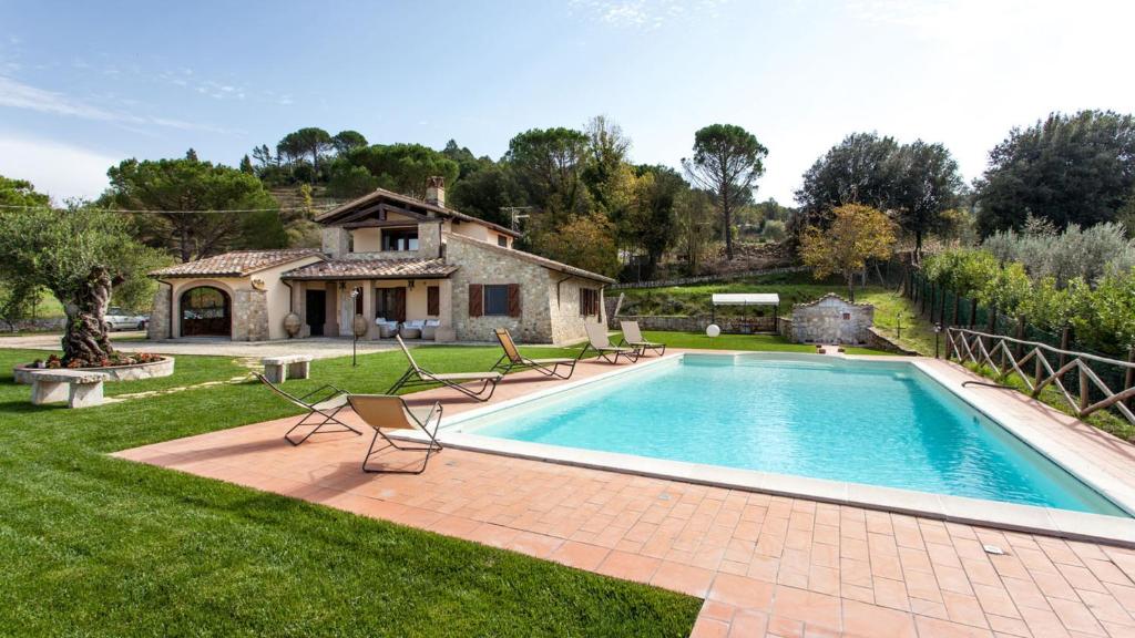 CollazzoneGENIUS LOCI 6, Emma Villas的庭院中的游泳池,带椅子和房子