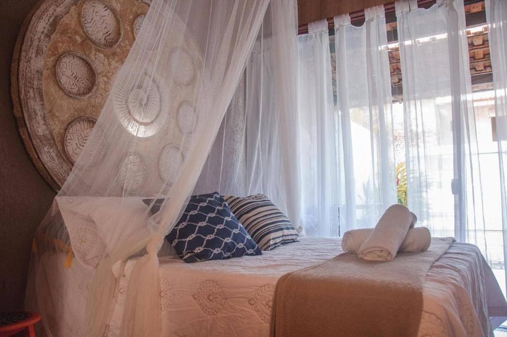 阿拉鲁阿马Loft Caeté的一间卧室配有一张天蓬床和窗户