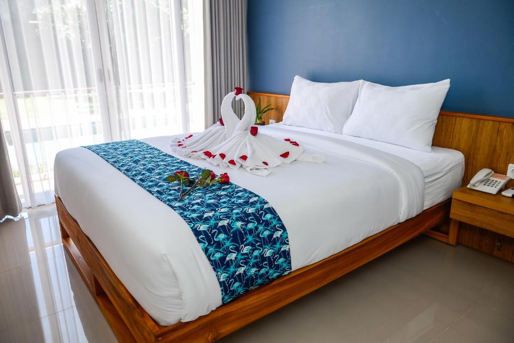 库塔RakaAyu Kuta的一间卧室配有一张床,床上有毛巾