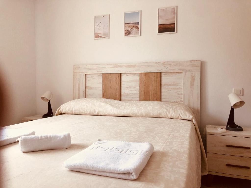拉瓜迪亚Apartamentos "EL BARCO"的一间卧室配有一张床,上面有两条毛巾