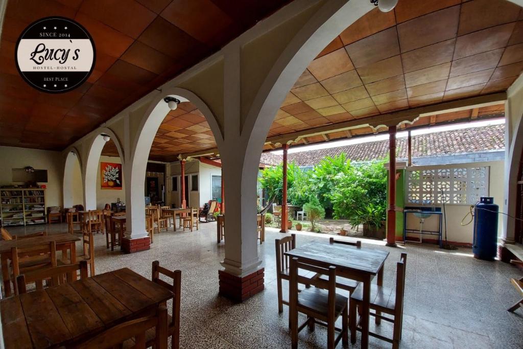 格拉纳达Casa Lucys Hostal的一间在房间内配有桌椅的餐厅