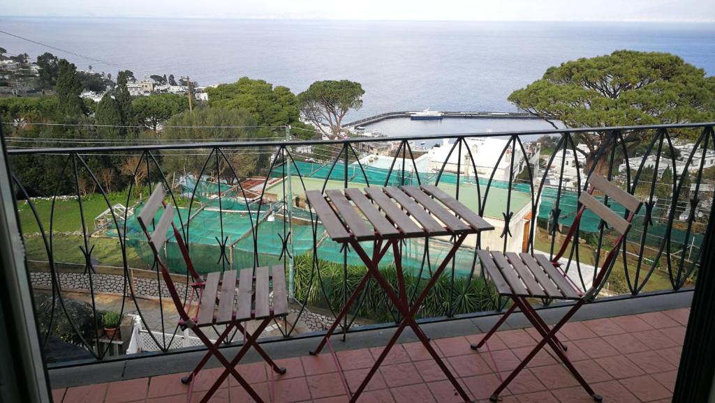 卡普里拉玛克塞拉度假屋的一个带两把椅子的阳台和一个游泳池