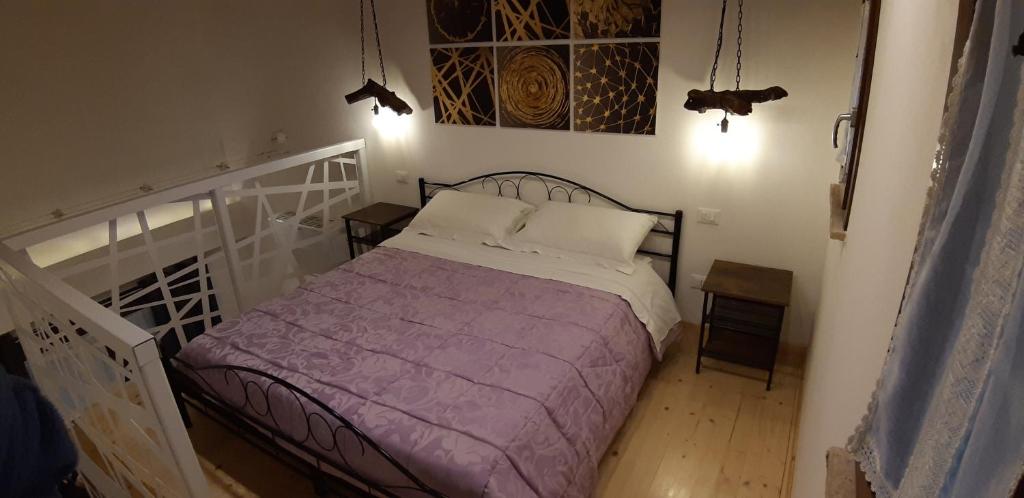 耶西B&B il Fienile del Borgo的一间卧室配有一张带紫色毯子的床