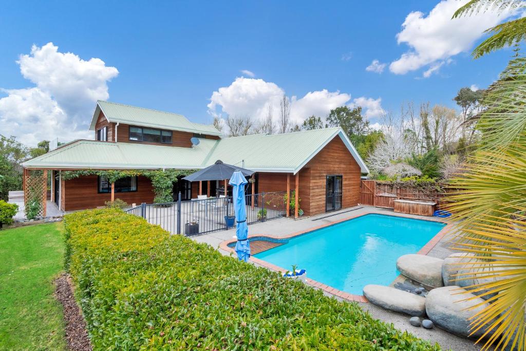 奥克兰Dangela Boutique Lodge的一个带游泳池和房子的度假屋
