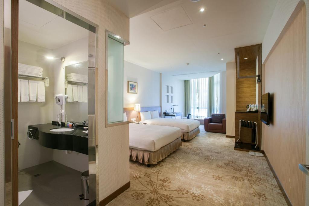 台北台糖台北会馆的酒店客房设有床、水槽和镜子
