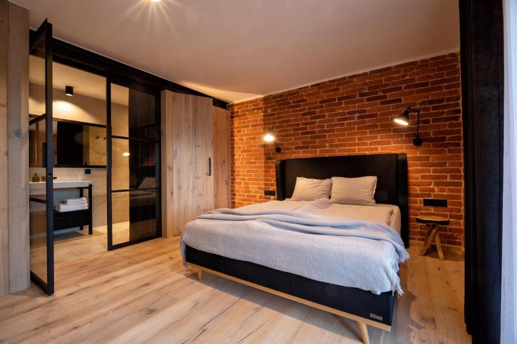 别尔斯克-比亚拉Jazzowa Chata的一间卧室设有一张大床和砖墙