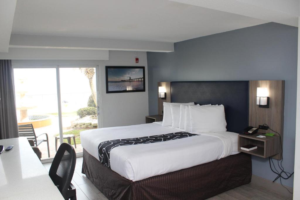 代托纳海滩代托纳比奇海滨拉金塔旅馆及套房的酒店客房设有一张大床和一个阳台。