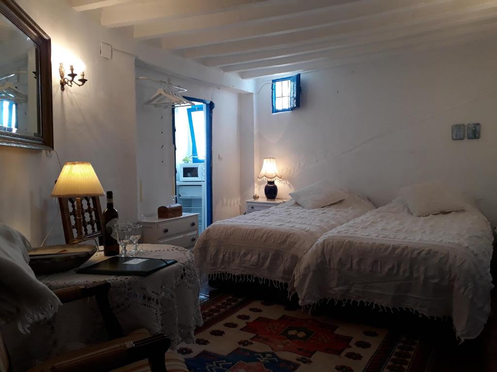 孔佩塔Guesthouse La Tienda Cómpeta 21b的一间卧室设有两张床、一张桌子和一个窗口