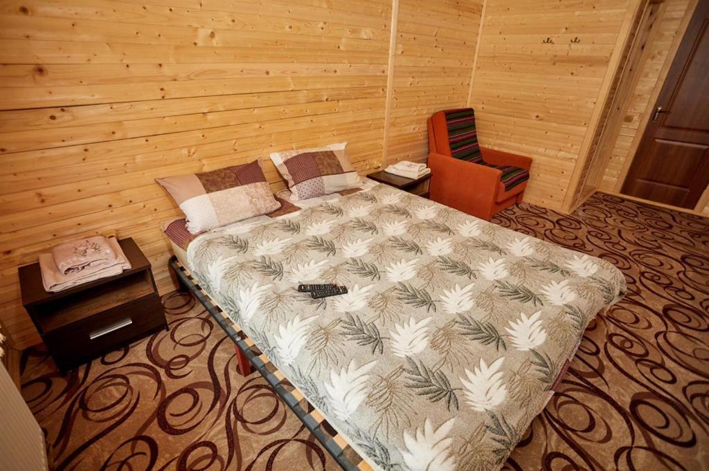 米戈韦Villa Na uzlissi的一间卧室配有一张大床和一把椅子