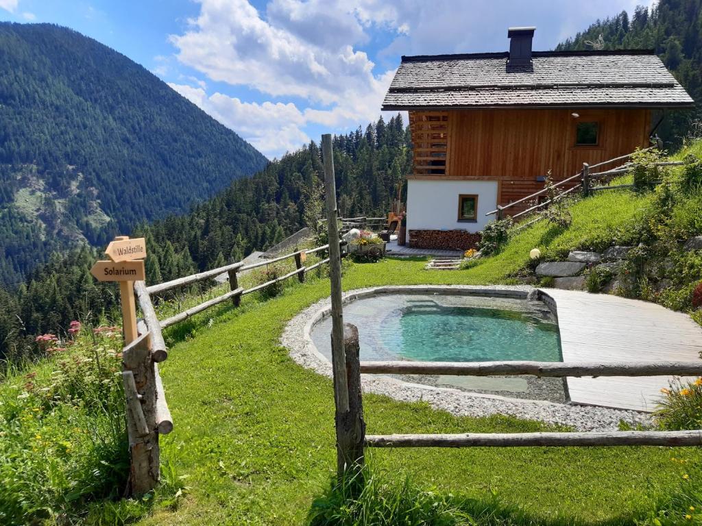 圣维吉利奥Naturchalet的山间小屋,前面设有热水浴池