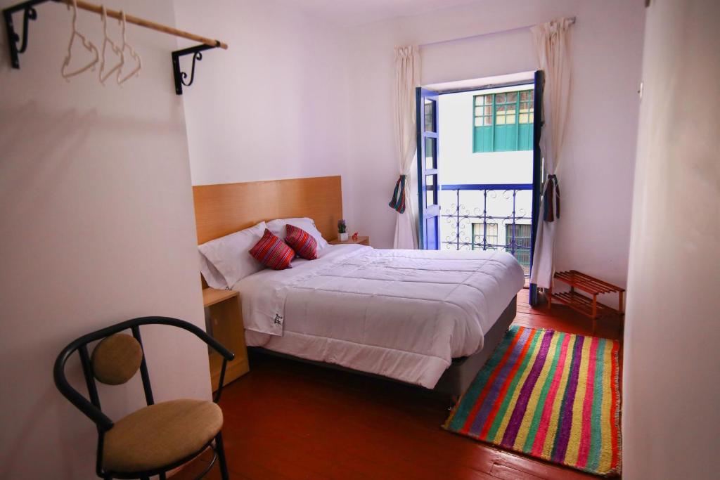 库斯科CASONA TORDO - A 3 Cdras de la Plaza - Habitaciones con baño privado的一间卧室设有一张床、一个窗口和一把椅子