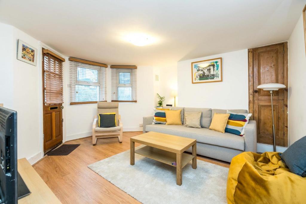 伦敦NEW Stylish 1 Bedroom Flat with Garden London的客厅配有沙发和桌子