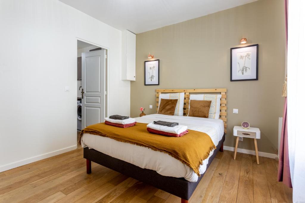 圣旺StayLib - Lovely 2 rooms porte de Montmartre的一间卧室配有一张大床和两个枕头