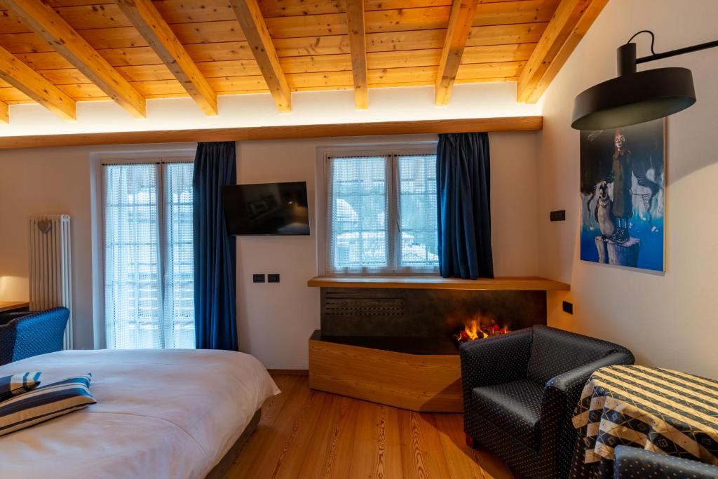 马代西莫阿尔皮娜体育酒店的一间卧室配有一张床和一个壁炉
