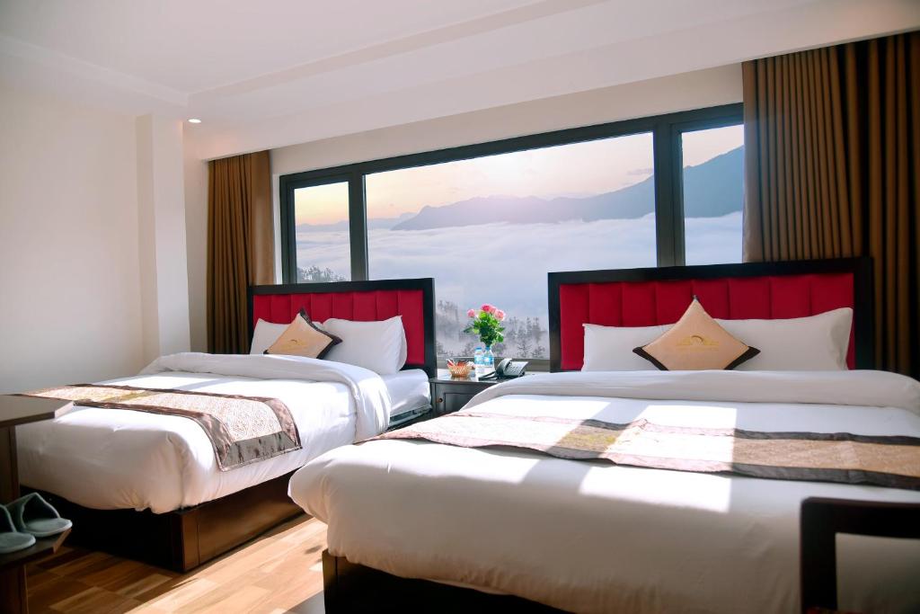 萨帕Hung Vuong hotel的带大窗户的客房内的两张床