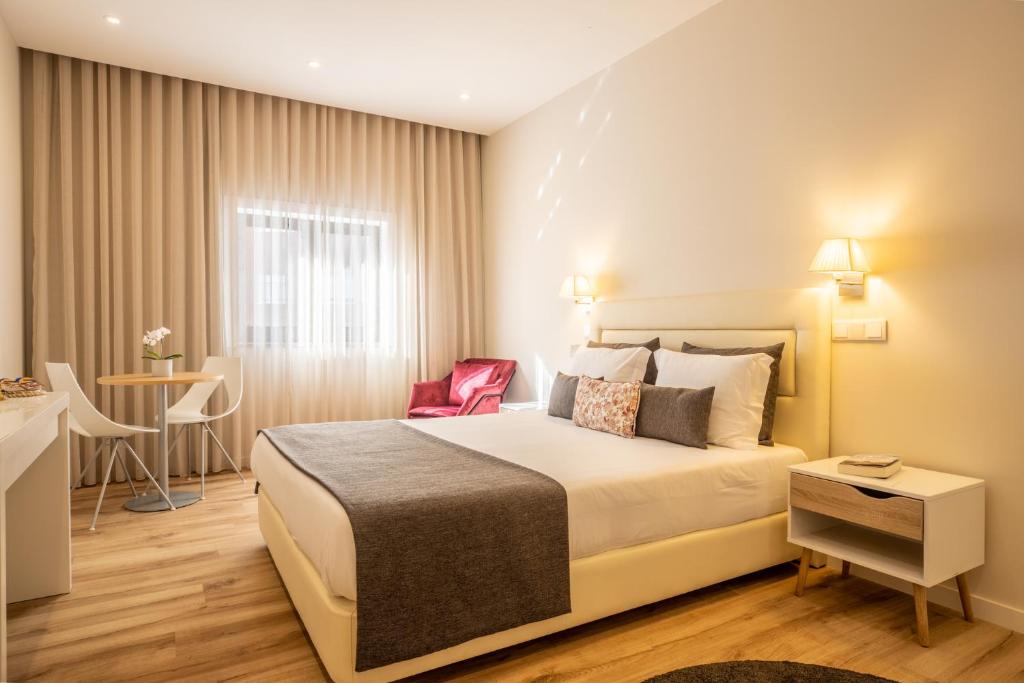 马托西纽什MyStay Matosinhos Centro的酒店客房配有一张床铺和一张桌子。