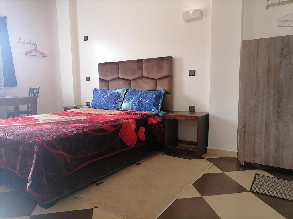 胡里卜盖ZELLAKA hôtel & café的一间卧室配有一张大床和一张桌子