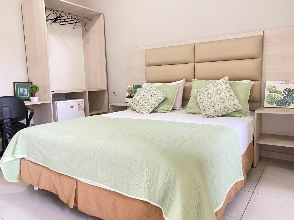 圣洛伦索Canarias Bed & Breakfast的一间卧室配有一张带绿色枕头的大床