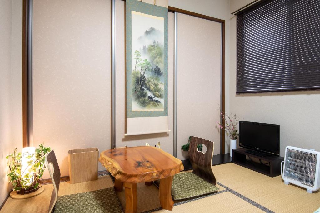 日光Garden Nikko Guest House的客厅配有木桌和椅子