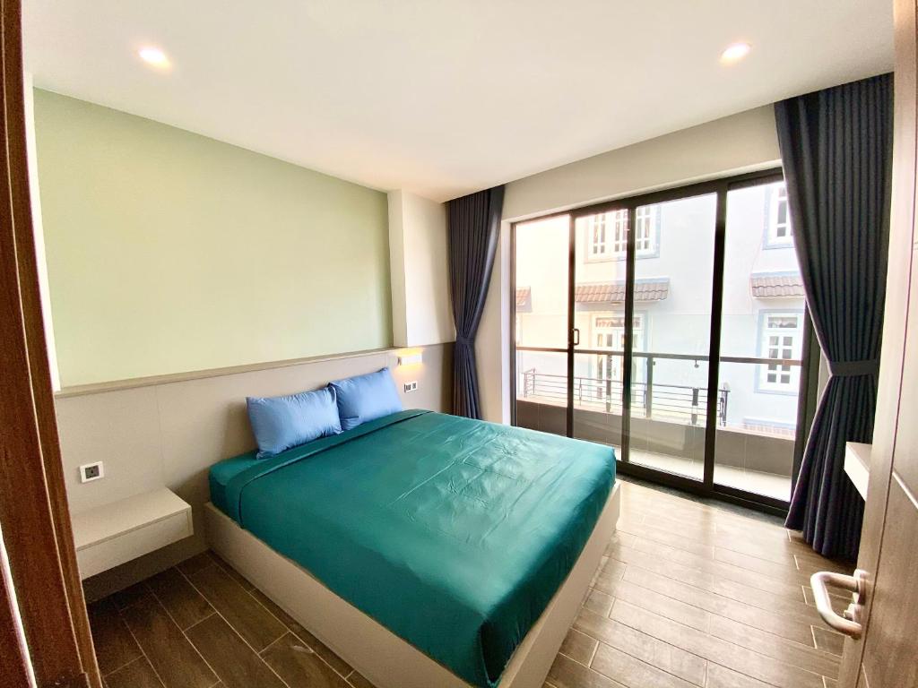 大叻Kim Oanh Apartment的一间卧室设有一张床和一个大窗户