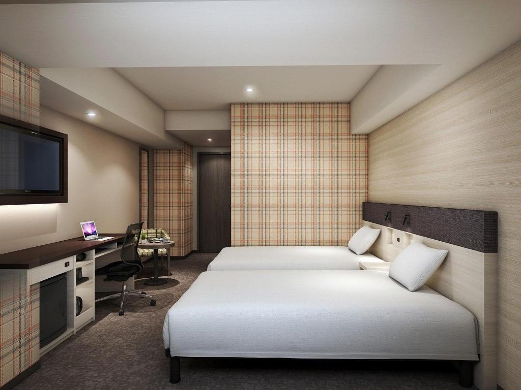 冈山Smile Hotel Okayama的一间卧室配有一张床、一张书桌和一台电视。
