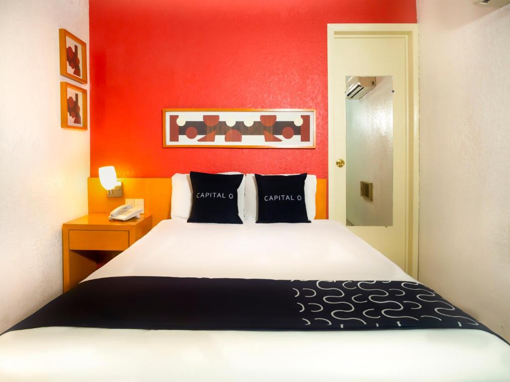墨西卡利Hotel Regis的一间卧室设有一张床和红色的墙壁