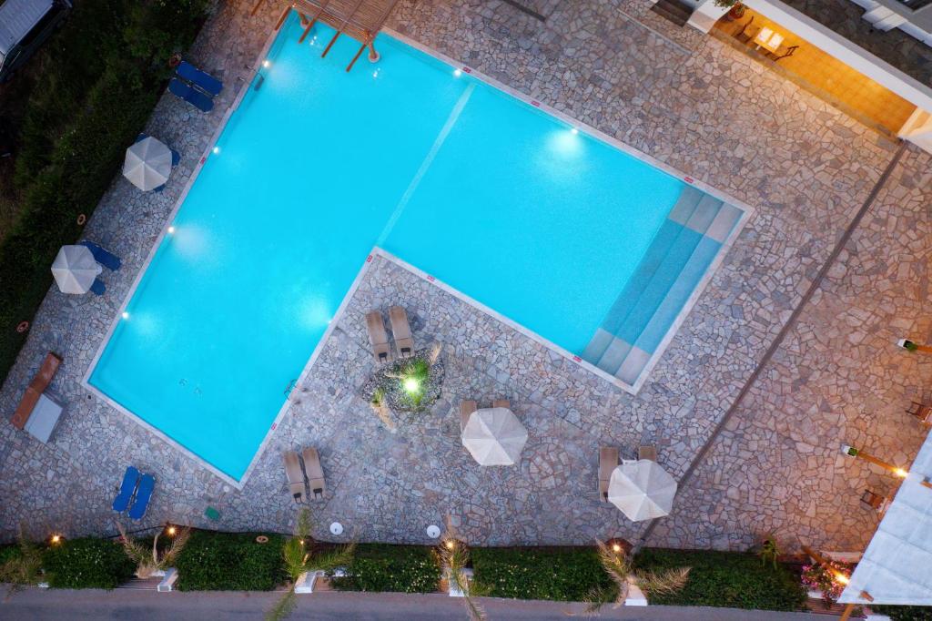 赫索尼索斯Oasis Beach Hotel - Adults Only的享有带椅子的大型游泳池的顶部景色