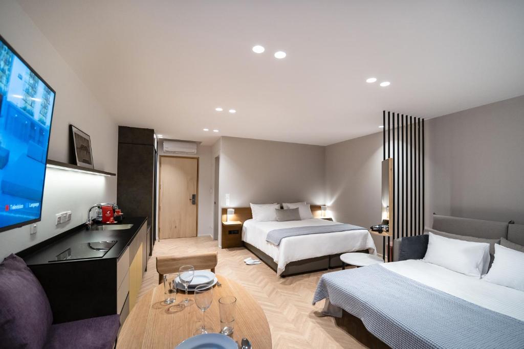 利马索尔Alinea Suites Limassol Center的酒店客房设有两张床和一台平面电视。