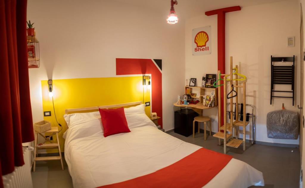 摩德纳R&B La Pomposa dei Motori的一间卧室配有一张红色和黄色床头板的床
