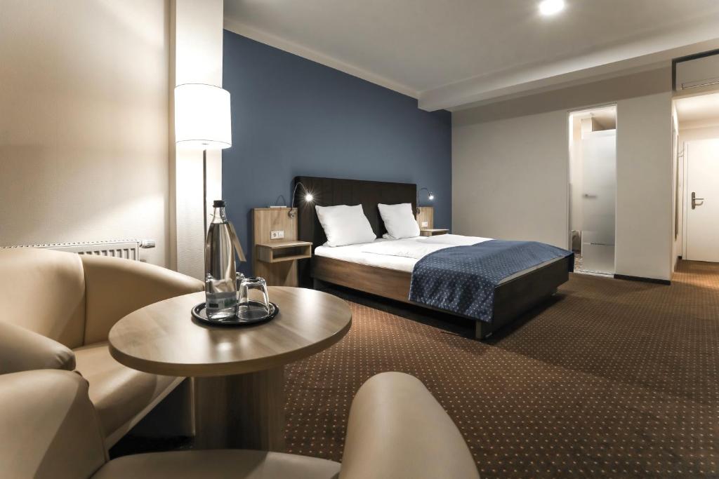 SteinfeldBergmark Hotel的酒店客房配有床、沙发和桌子。