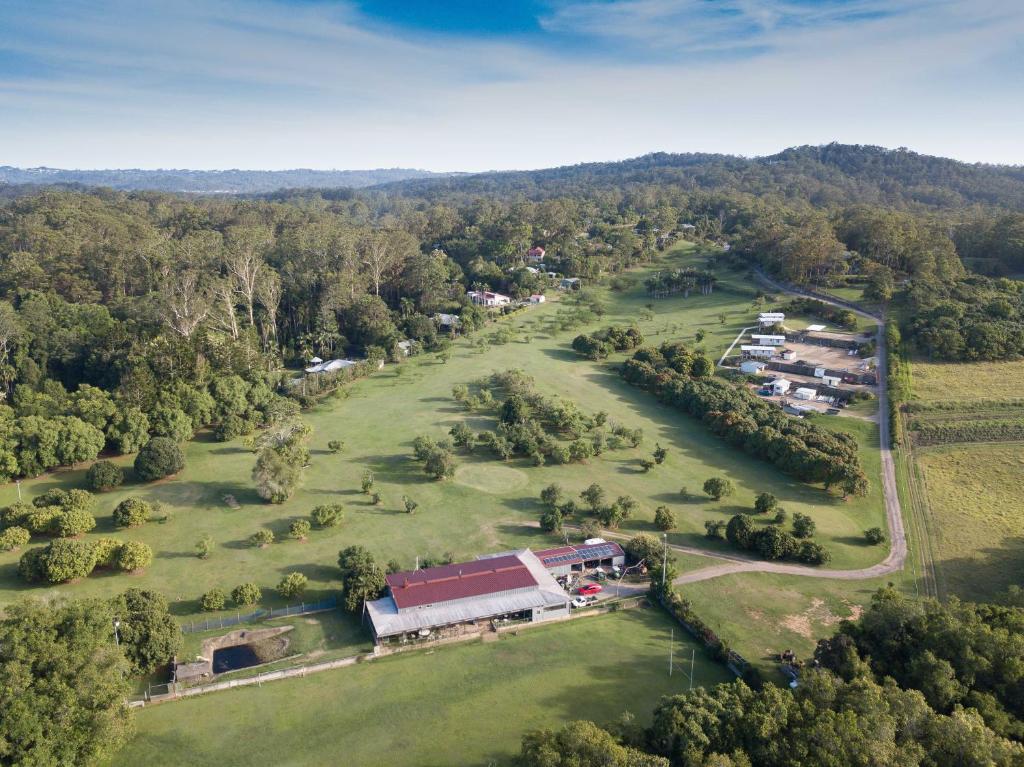 DiddillibahSunshine Coast retreat your own private golf course的享有公园的空中景致,设有谷仓和树木