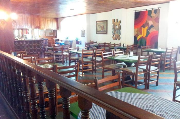 阿瓜斯迪林多亚Hotel Cavalinho Branco的用餐室配有木桌和椅子