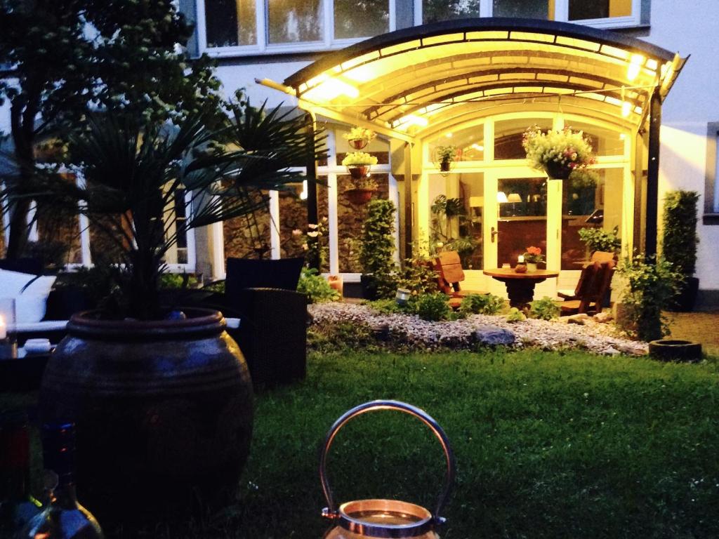 格尔利茨Dein Gutshof Hotel & Ferienwohnungen的坐在房子院子中的一个大花瓶
