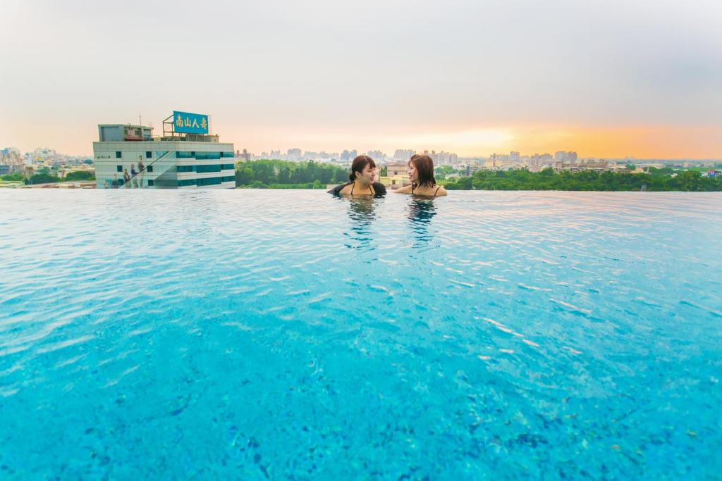 嘉义市承亿文旅-桃城茶样子的两个女人在酒店的无边游泳池里