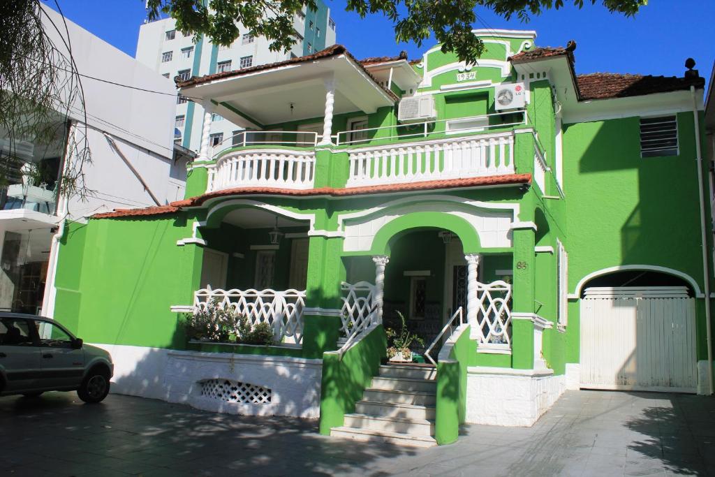 桑托斯博萨达比拉马酒店的街道上的绿色房子,设有白色阳台