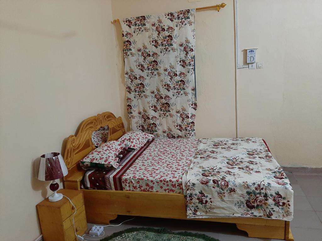 巴马科Appartement chambre salon climatisées, cuisine的小卧室配有一张带花卉床罩的床
