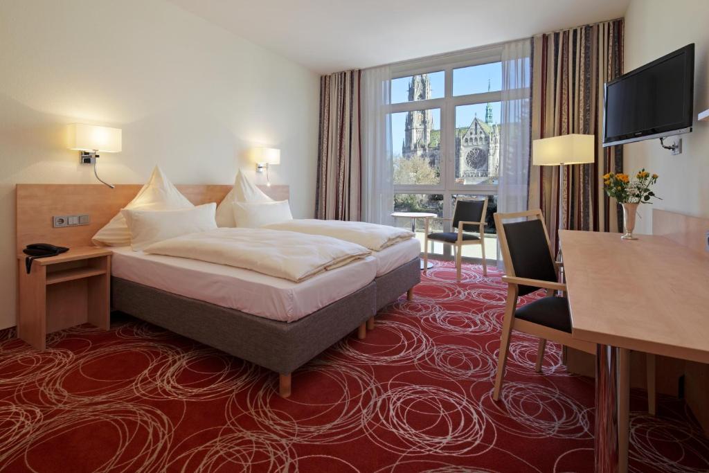 施派尔Hotel Löwengarten的酒店客房设有一张床和一个大窗户